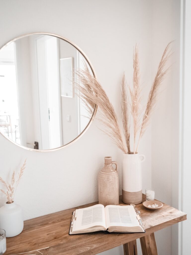 stylishly decorated entryway featuring popular decor elements, including books and a chic circle mirror, along with tasteful decorative accents.